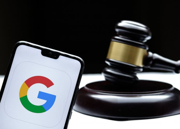 Logo do Google em um smartphone ao lado de um martelo de juiz