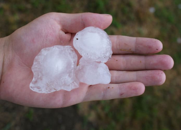 Três grandes pedras de granizo em uma mão humana