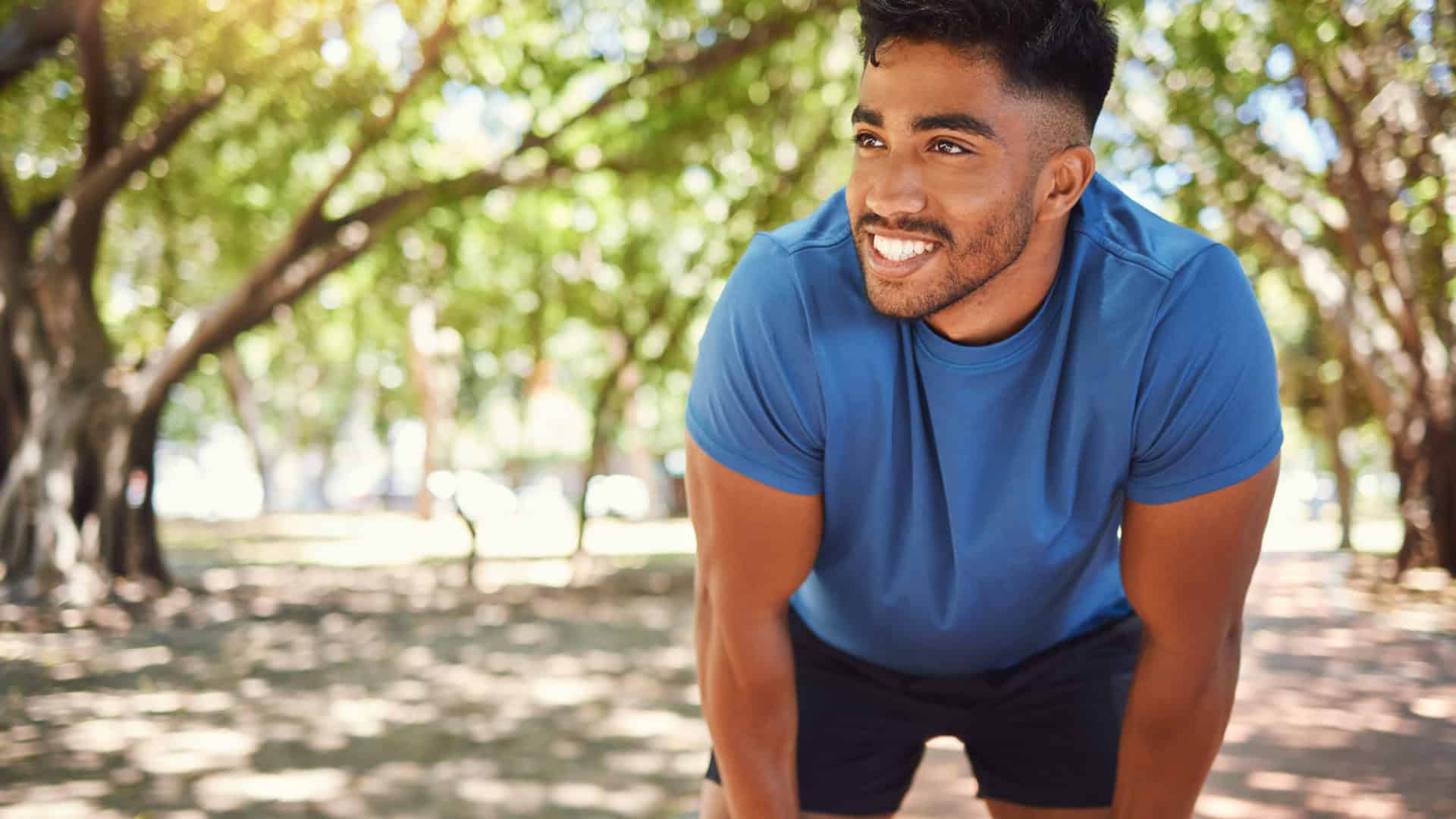 Homem jovem e saudável pratica corrida em parque
