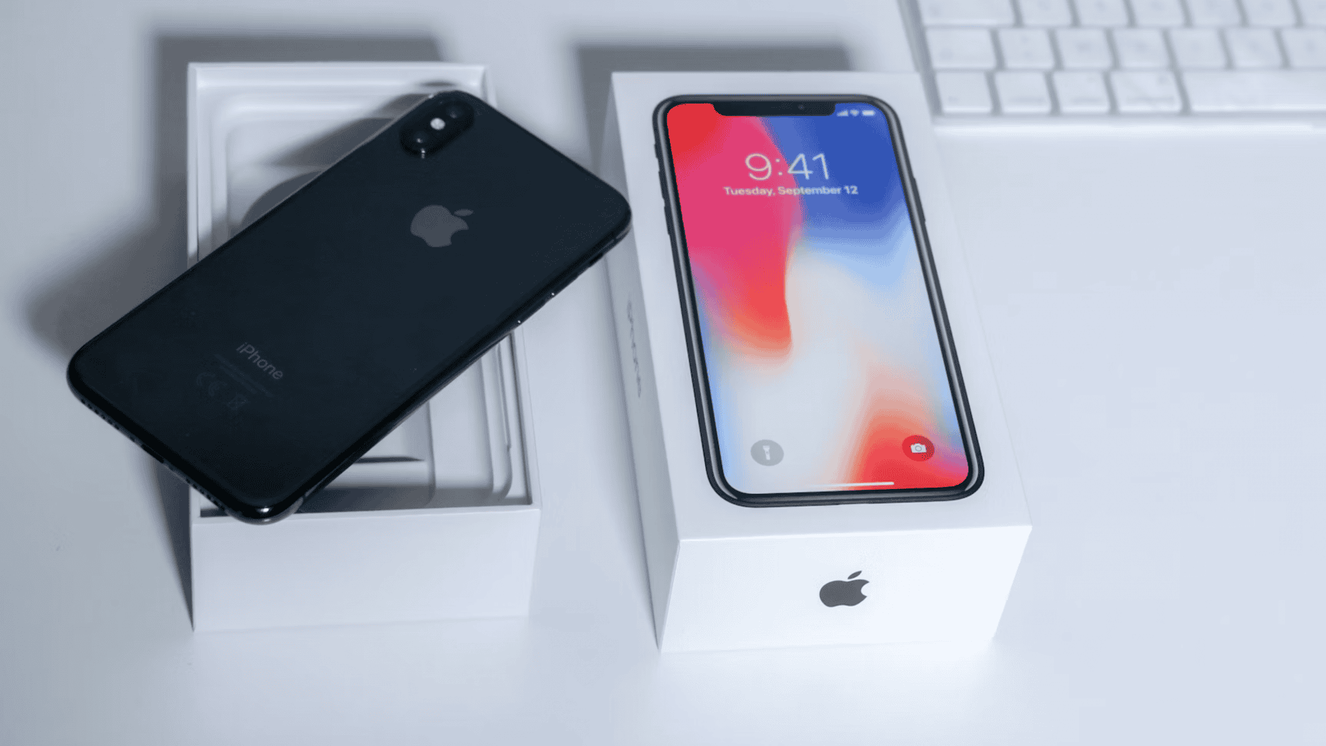 iPhone preto em cima de caixa sobre mesa branca
