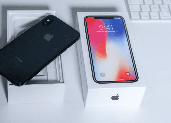 iPhone preto em cima de caixa sobre mesa branca