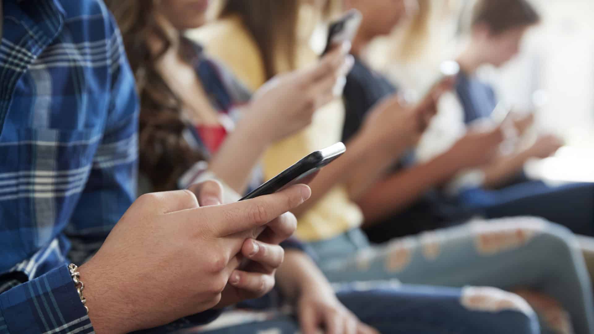 Close de crianças mexendo em celulares