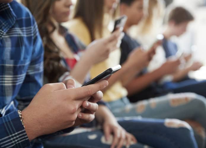 Close de crianças mexendo em celulares
