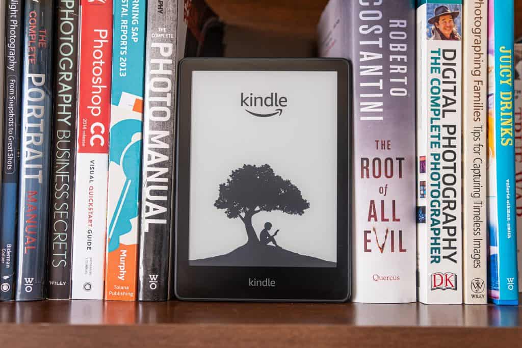 Livros dispostos em uma estante; no meio, um Kindle