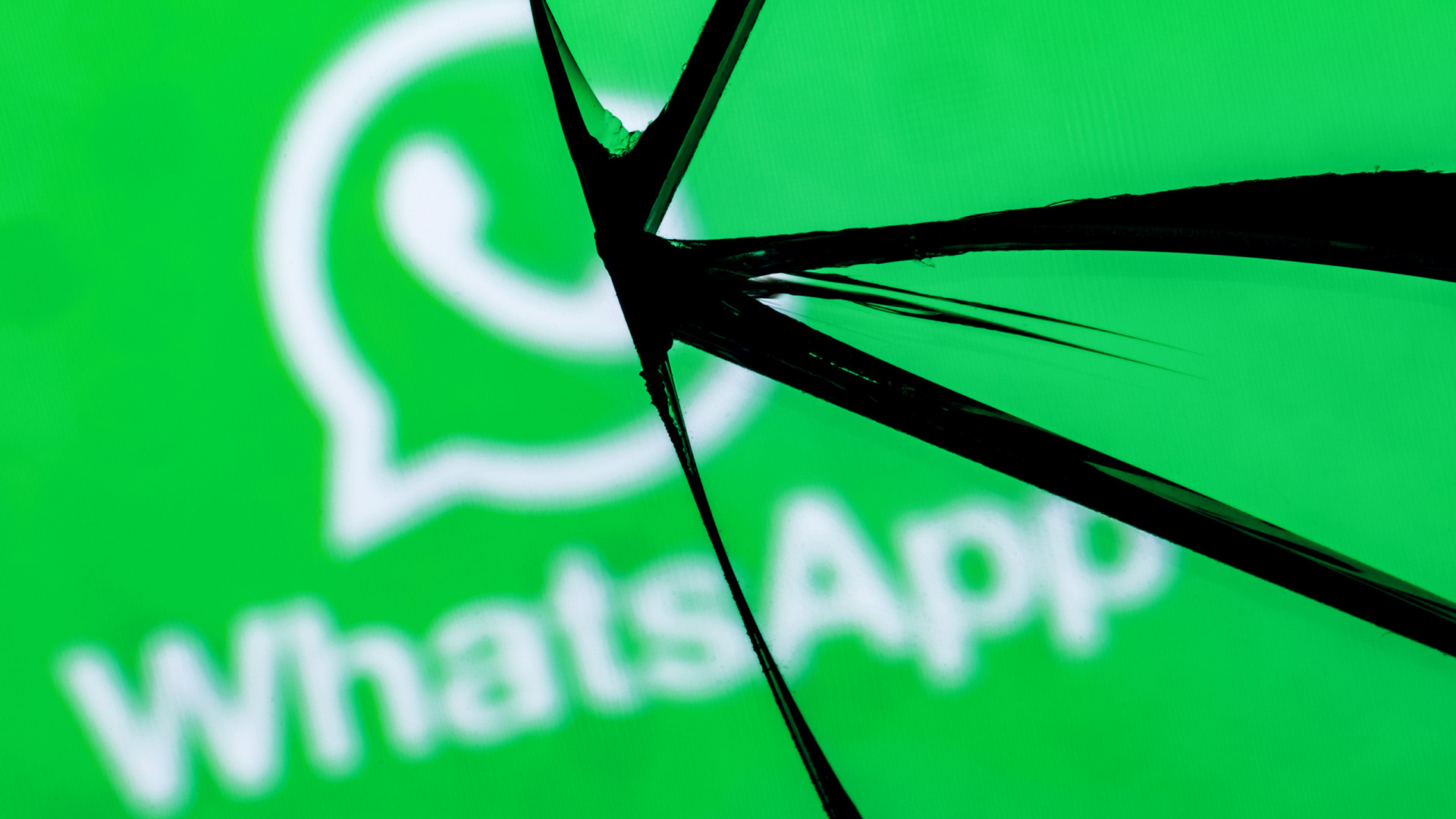 Vidro quebrado com o logo do WhatsApp atrás