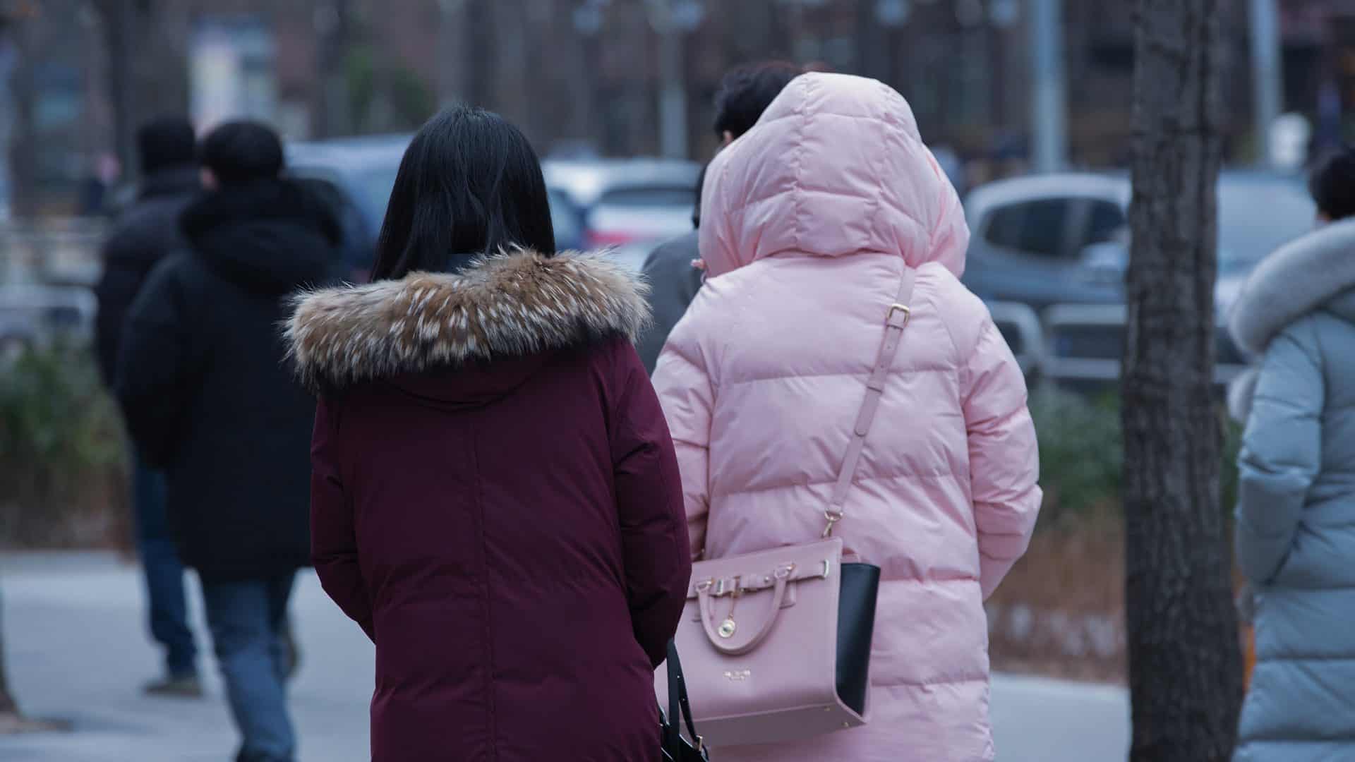 Duas mulheres de costas e com blusas de frio