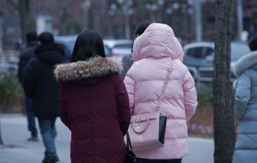 Duas mulheres de costas e com blusas de frio