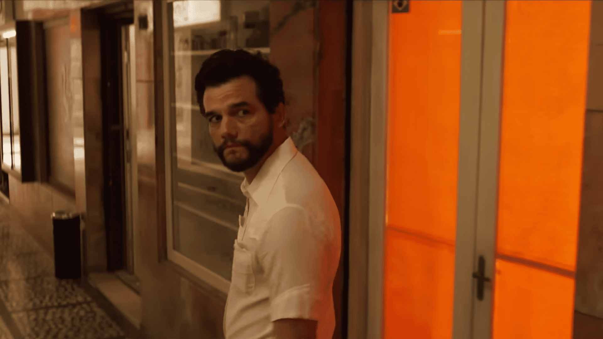 Wagner Moura de perfil e olhando para trás