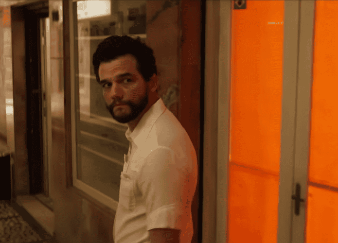 Wagner Moura de perfil e olhando para trás