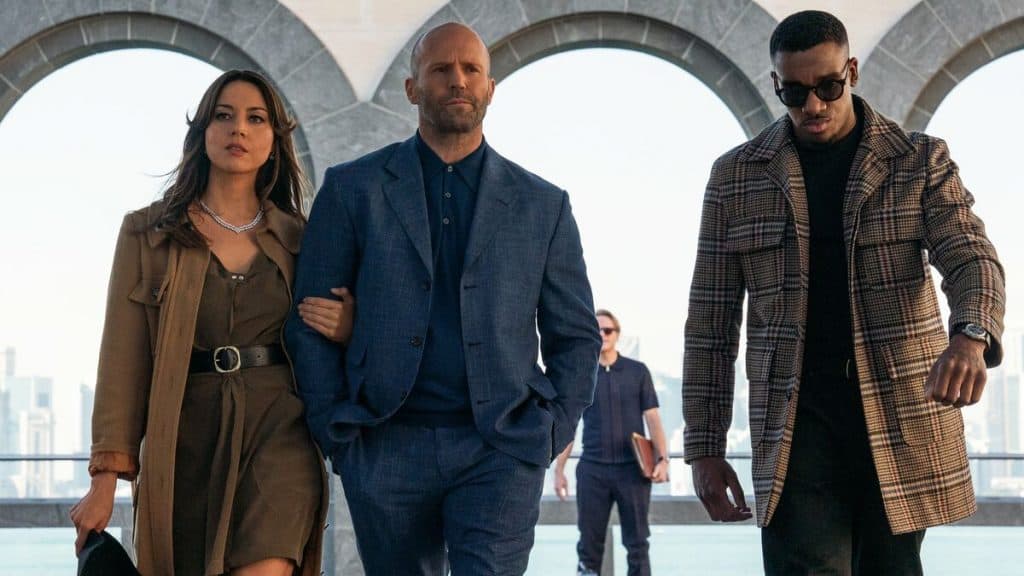 imagem mostra dois homens e uma mulher andando lentamente