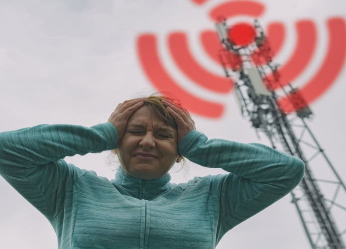Mulher segura a cabeça perto de torre BTS (Base Transceiver Station). A função da BTS é prover a conexão de rádio para a estação móvel (celular) Radiação nociva do conceito de transmissores de rede celular 5G
