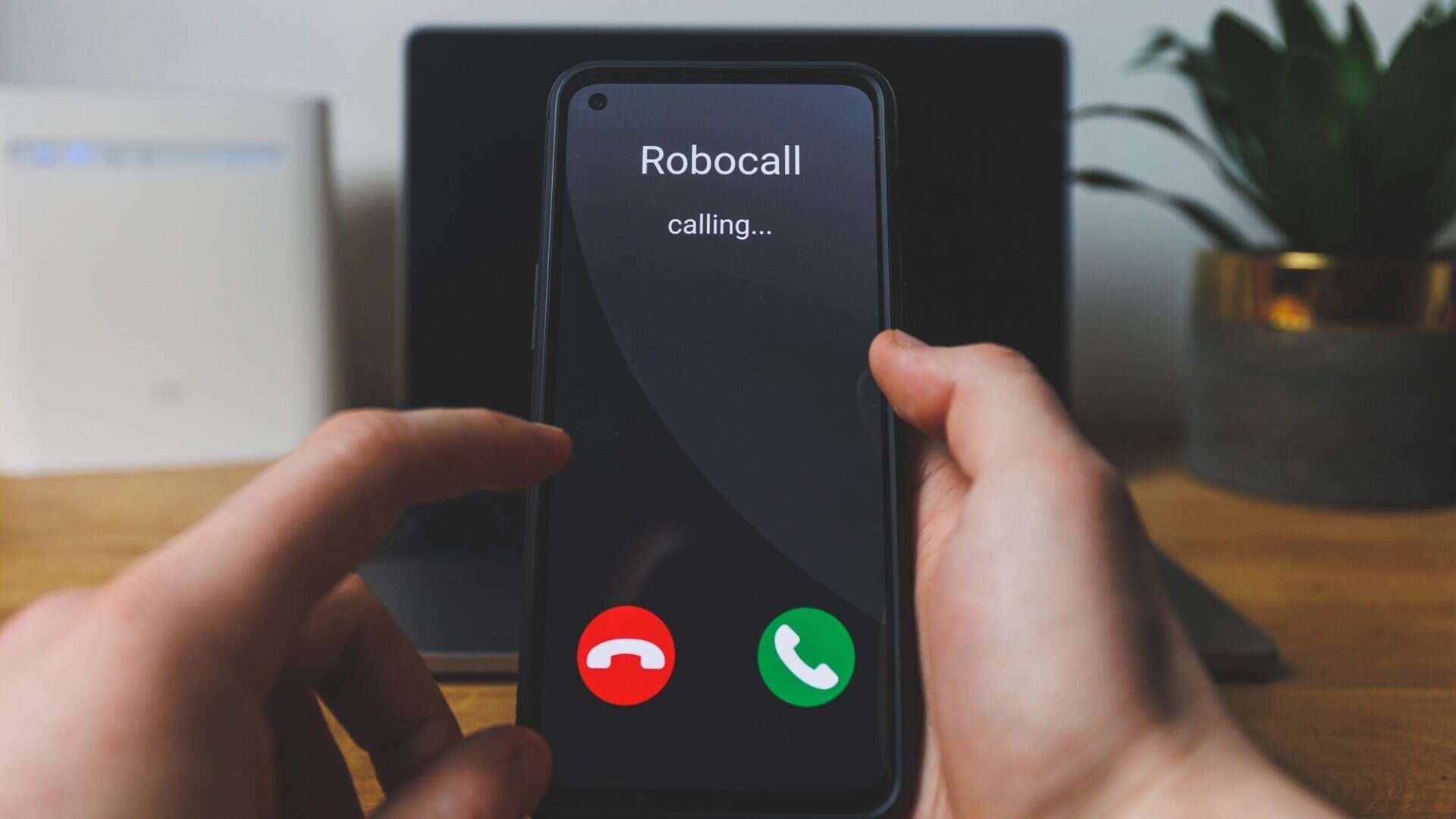 mãos seguram um smartphone com uma chamada de robô aparecendo na tela