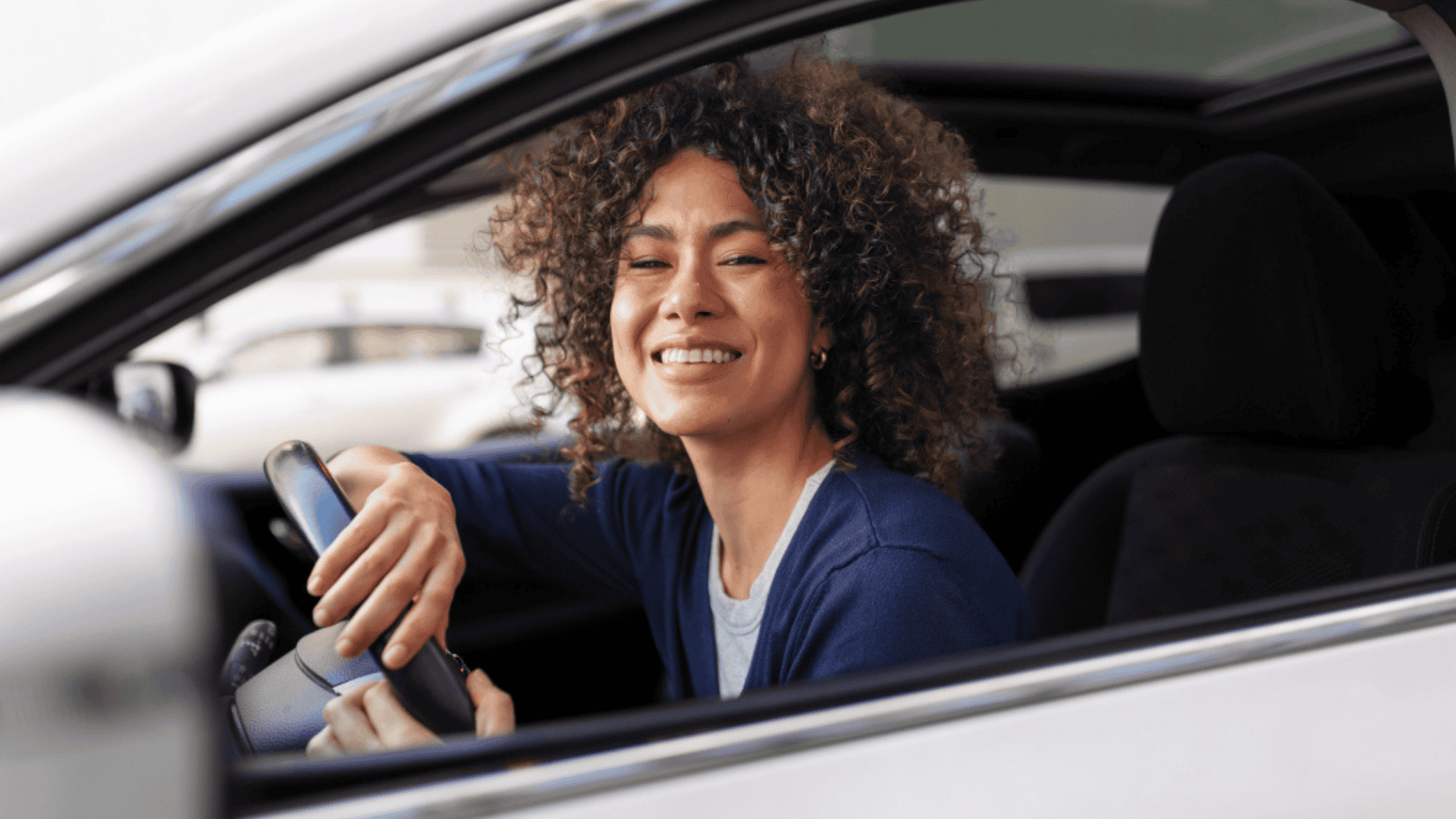 Mulher feliz com o próprio carro assegurado