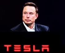 Foto de Elon Musk acima do logo da Tesla