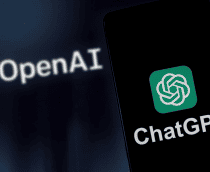 Aplicativo do ChatGPT sendo aberto em um celular e no fundo o logo da Open AI, empresa que desenvolveu a ferramenta