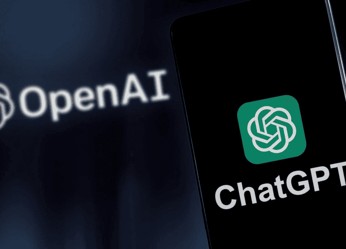 Aplicativo do ChatGPT sendo aberto em um celular e no fundo o logo da Open AI, empresa que desenvolveu a ferramenta