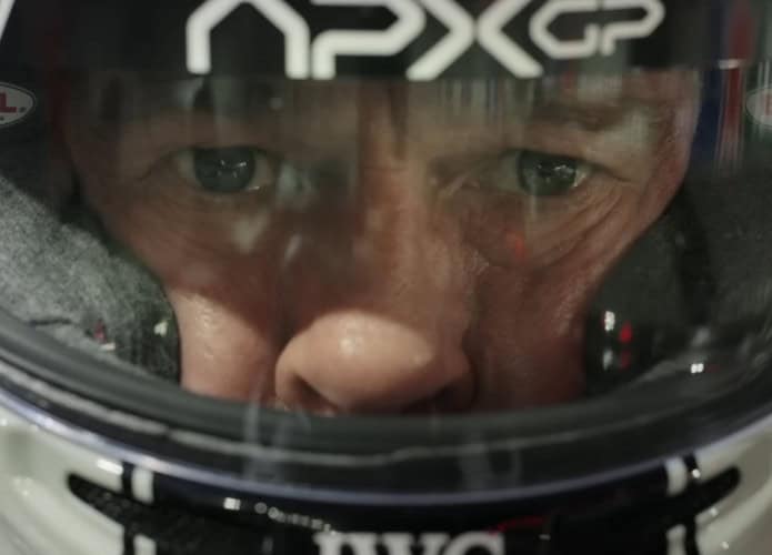 Close em rosto de Brad Pitt usando capacete de piloto em cena do filme F1 da Apple