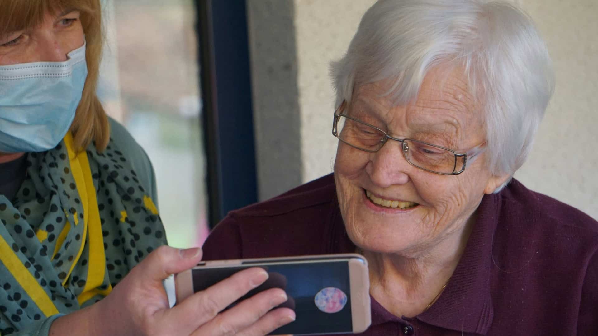 mulher idosa vendo o celular com outra mulher
