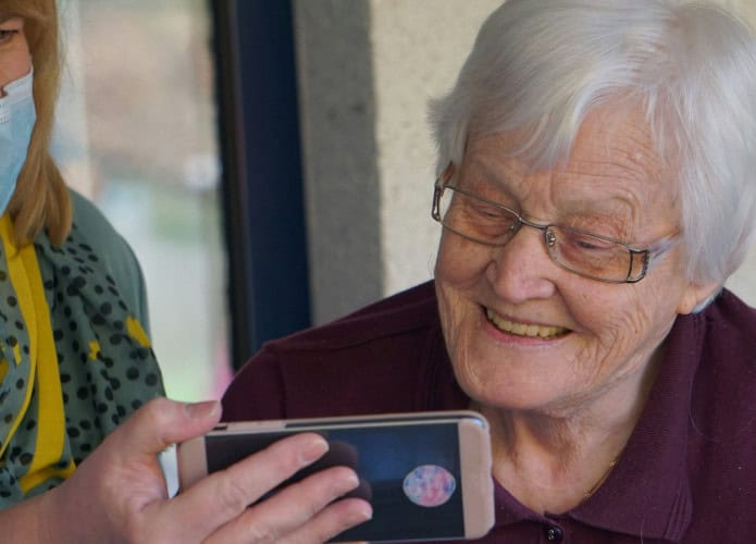 mulher idosa vendo o celular com outra mulher