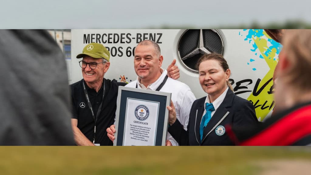 Piloto e funcionários da Mercedes-Benz segurando certificado do Guiness Book por conta de recorde quebrado com caminhão elétrico