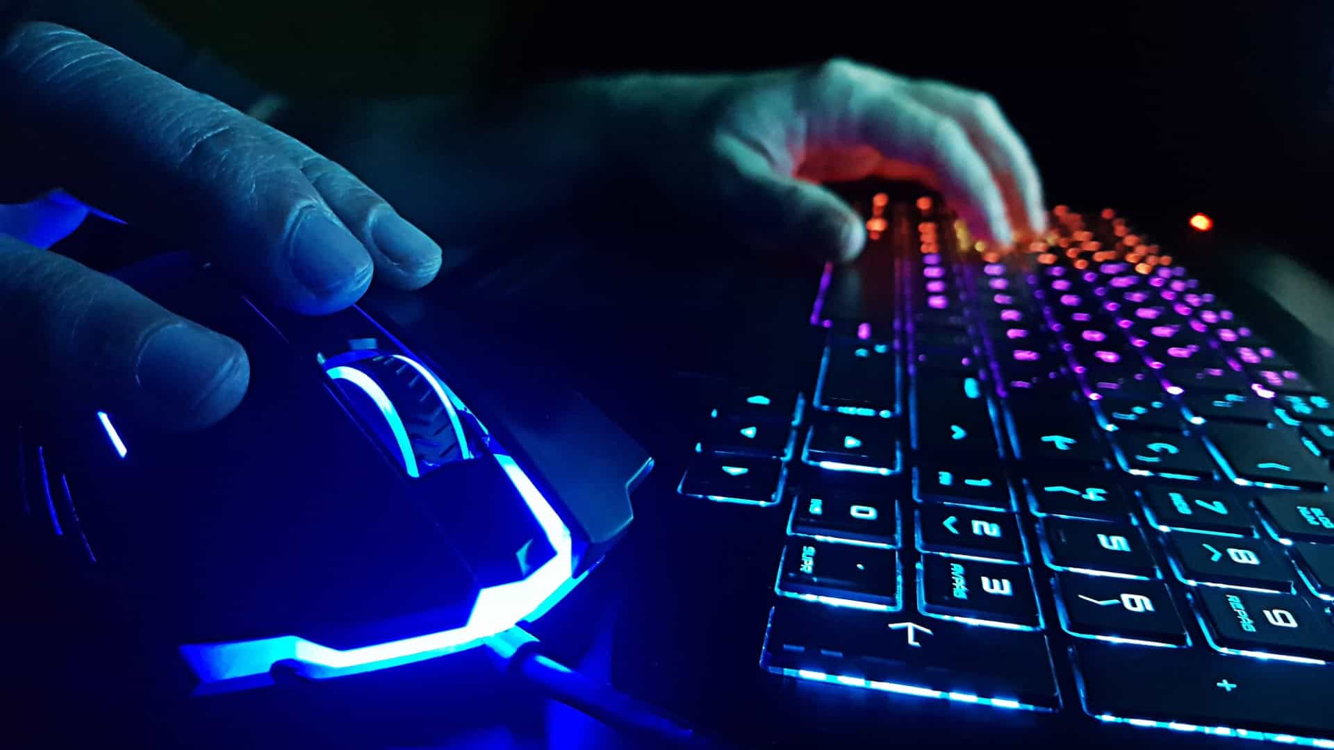 Pessoa jogando em pc gamer com detalhe para teclado e mouse