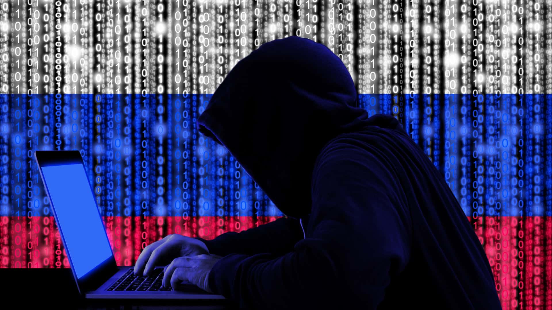 Hacker nas sombras, de perfil e com a bandeira russa atrás