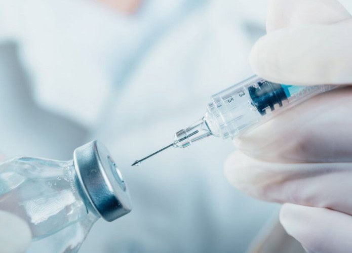 Médico segurando uma seringa com um frasco de vacina