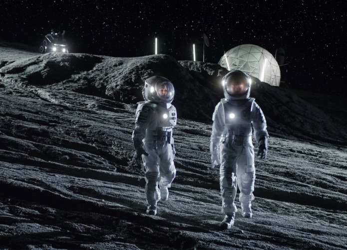Dupla de astronautas andando perto de base na Lua
