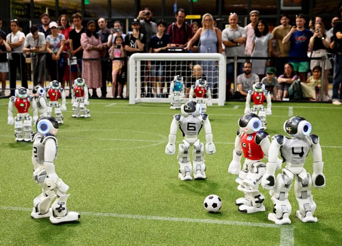 Robôs pequenos jogando futebol durante Copa do Mundo dos Robôs