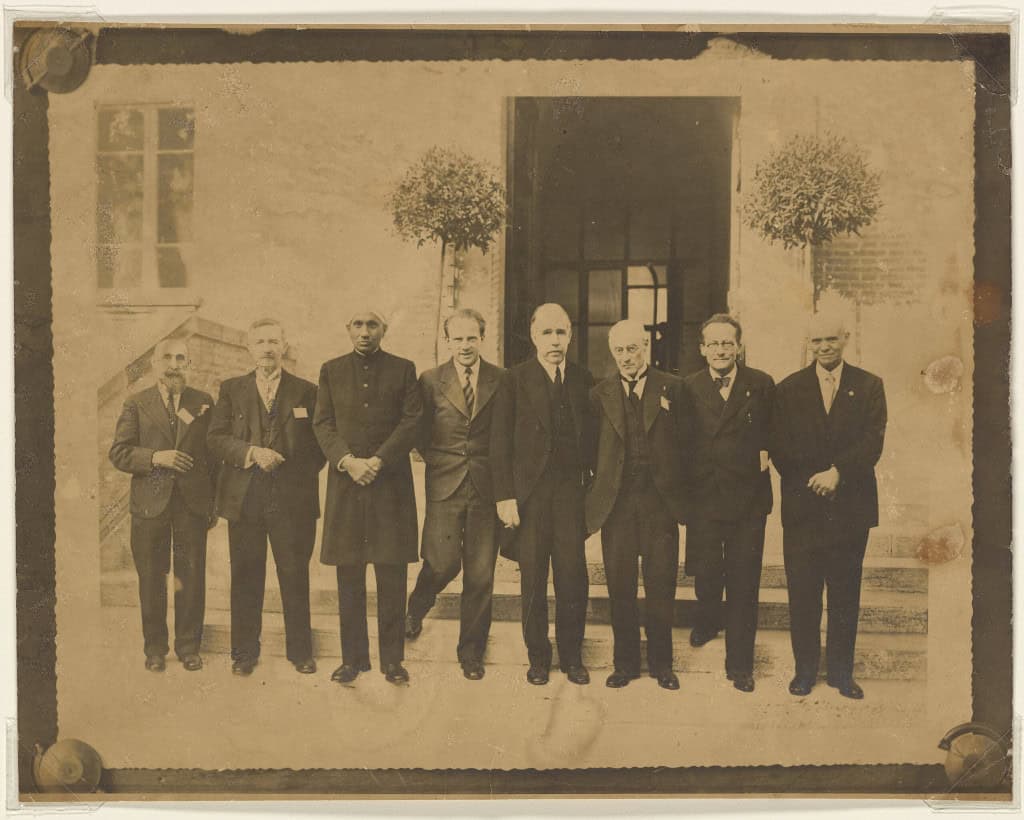 Fotografia histórica de cinco vencedores do Prêmio Nobel reunidos no Instituto Indiano de Ciência, incluindo Erwin Schrödinger, Niels Bohr e outros físicos renomados.