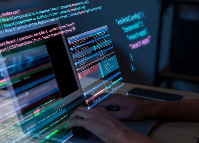 imagem de alguém que digita no computador com telas de códigos flutuantes