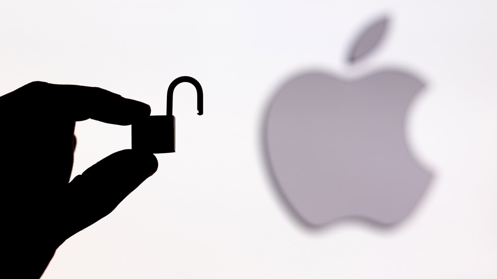 Logo da Apple ao lado da sombra de uma mão segurando um cadeado aberto