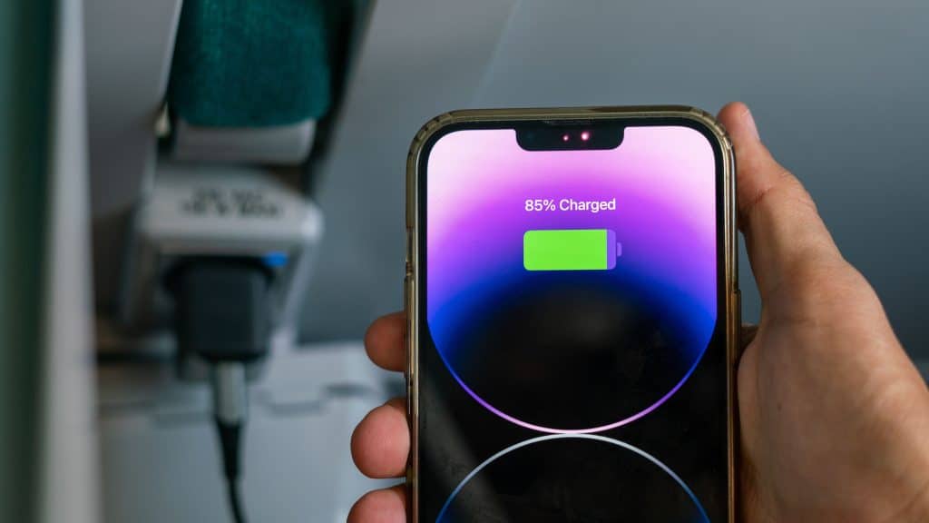 Homem segurando um iPhone 6 Space Gray com ícone de bateria na tela