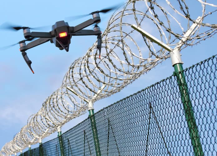Drone sobrevoando uma cerca de arame farpado