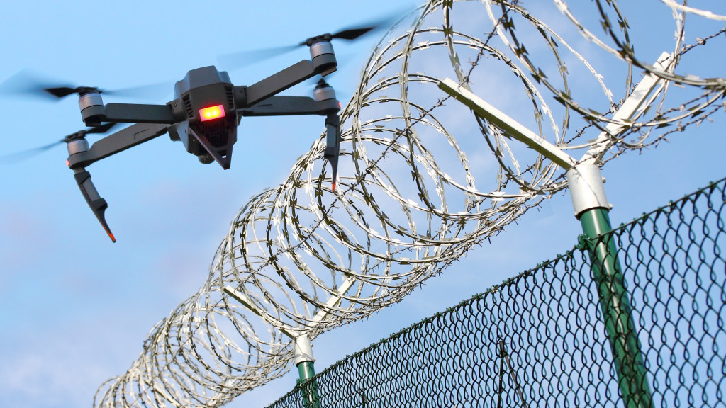 Drone sobrevoando uma cerca de arame farpado