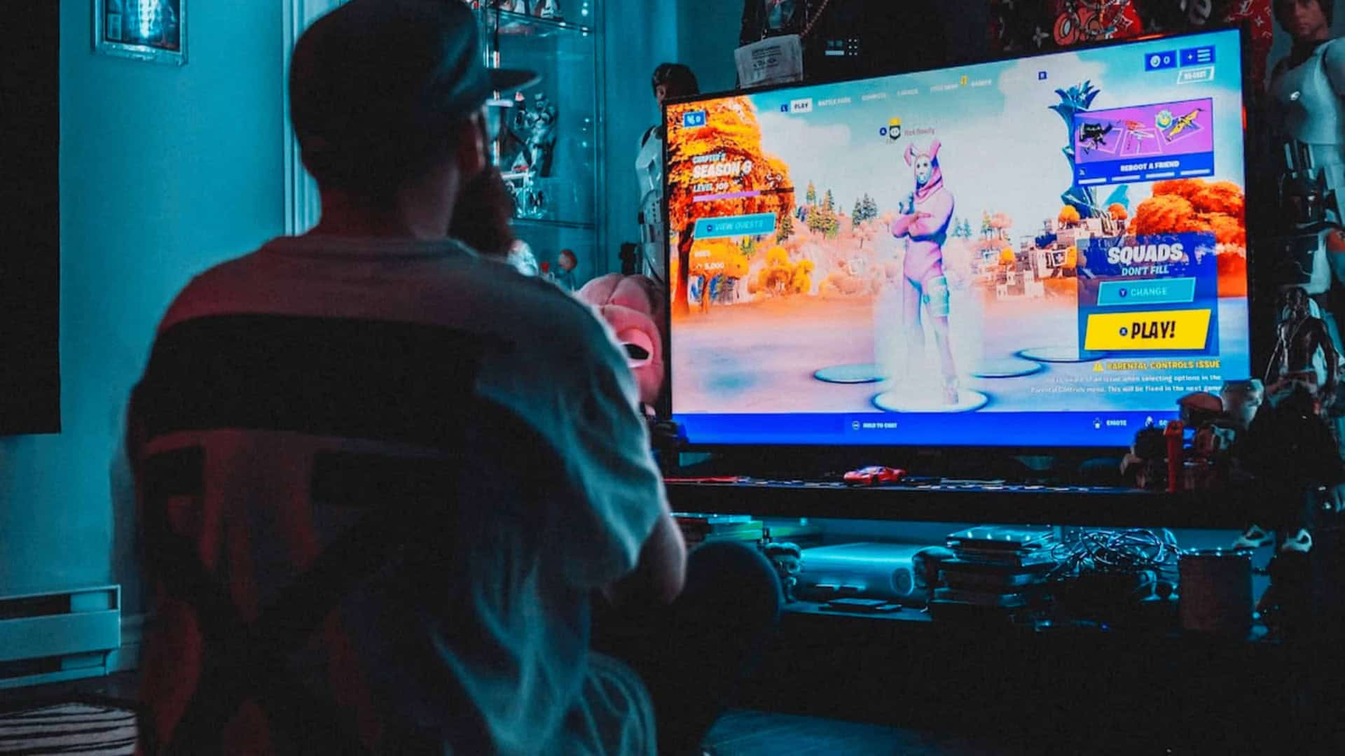 Pessoa jogando Fortnite em frente a televisão