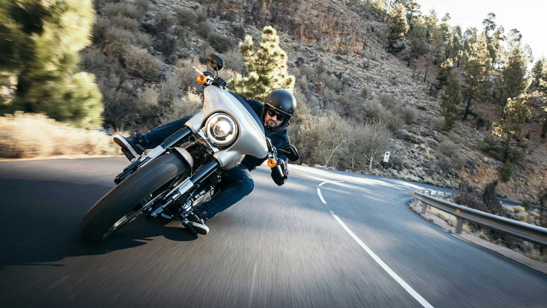 Imagem de um homem pilotando moto em uma curva na estrada
