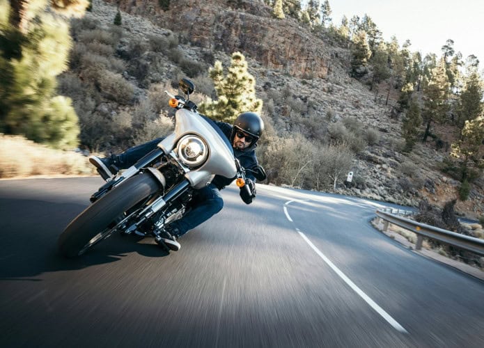 Imagem de um homem pilotando moto em uma curva na estrada