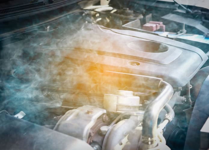 Imagem mostra motor de carro com problemas. O motor está superaquecendo e há fumaça causando danos ao motor.