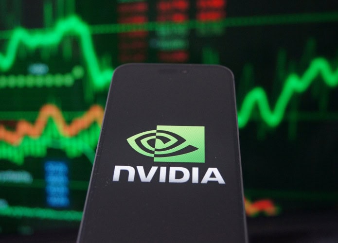 Logo da Nvidia em um smartphone com gráficos financeiros como plano de fundo desfocado