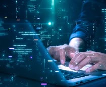 Close-up de mãos digitando em um laptop com código de programação brilhante e gráficos binários, simbolizando codificação de tecnologia de segurança cibernética ou desenvolvimento de software.