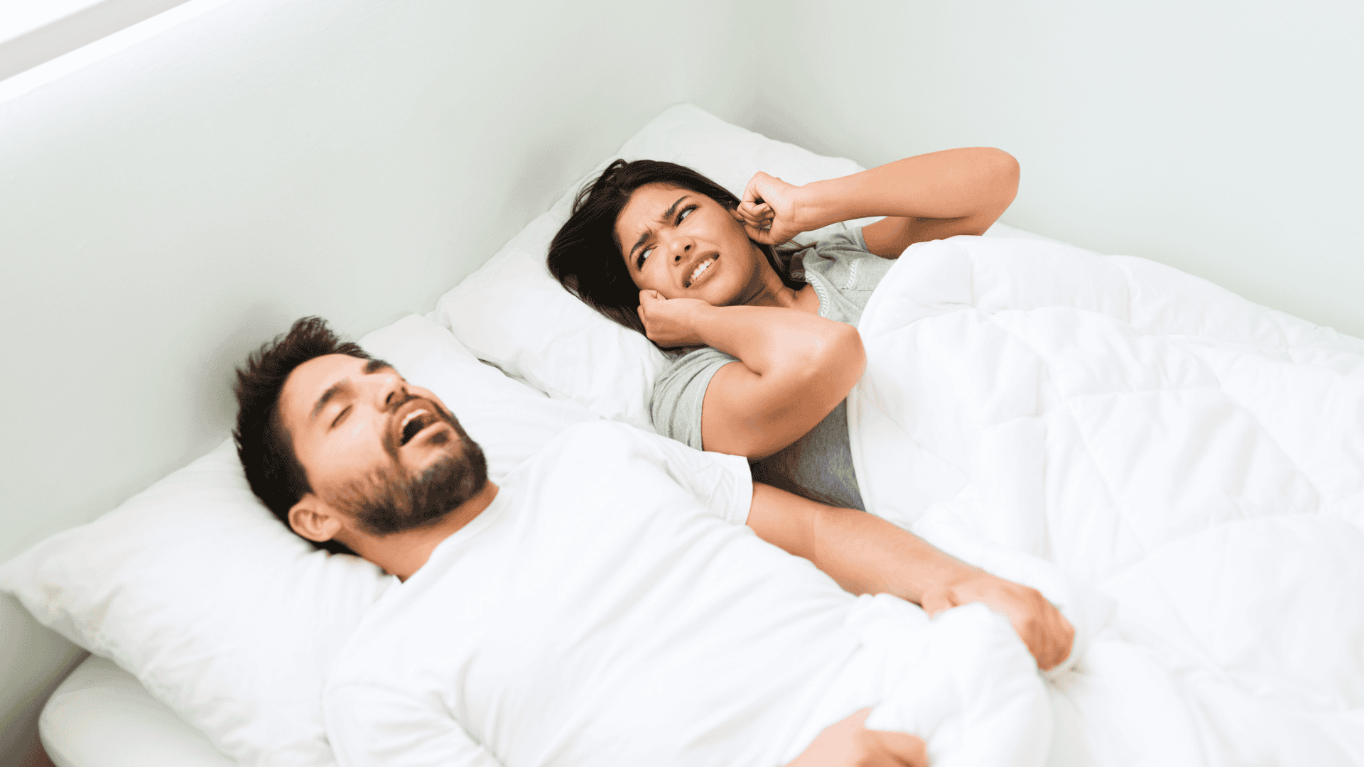 mulher tampando os ouvidos enquanto homem ronca