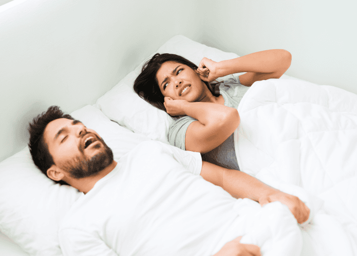 mulher tampando os ouvidos enquanto homem ronca