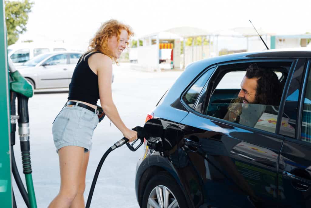 Mulher abastecendo o carro no posto de gasolina