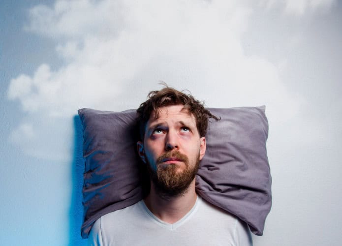 Homem com problemas/insônia, deitado na cama no travesseiro, olhando para nuvem cinza sobre sua cabeça, espaço de cópia