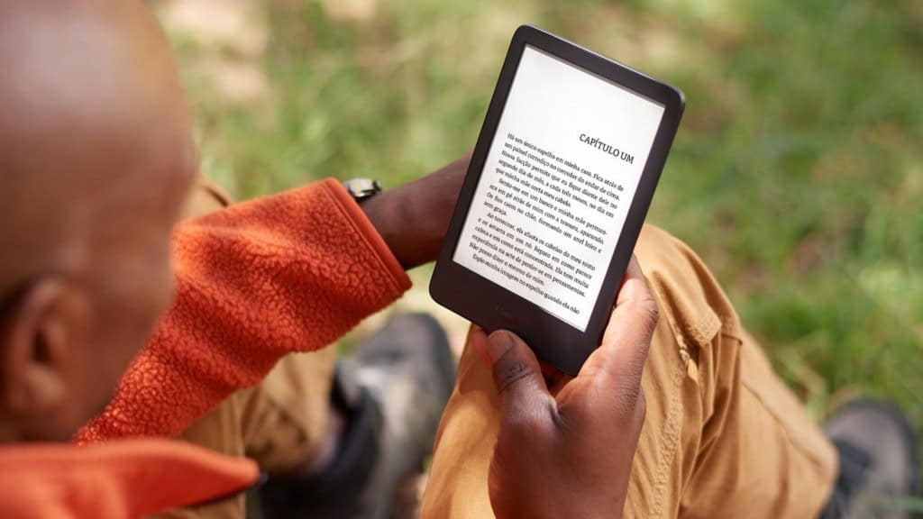 Homem lendo num Kindle num parque