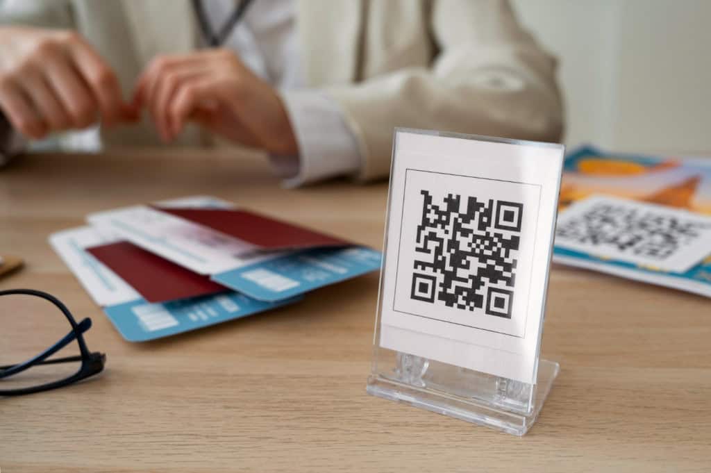 Qr code em um suporte em cima de uma mesa, com uma pessoa atrás