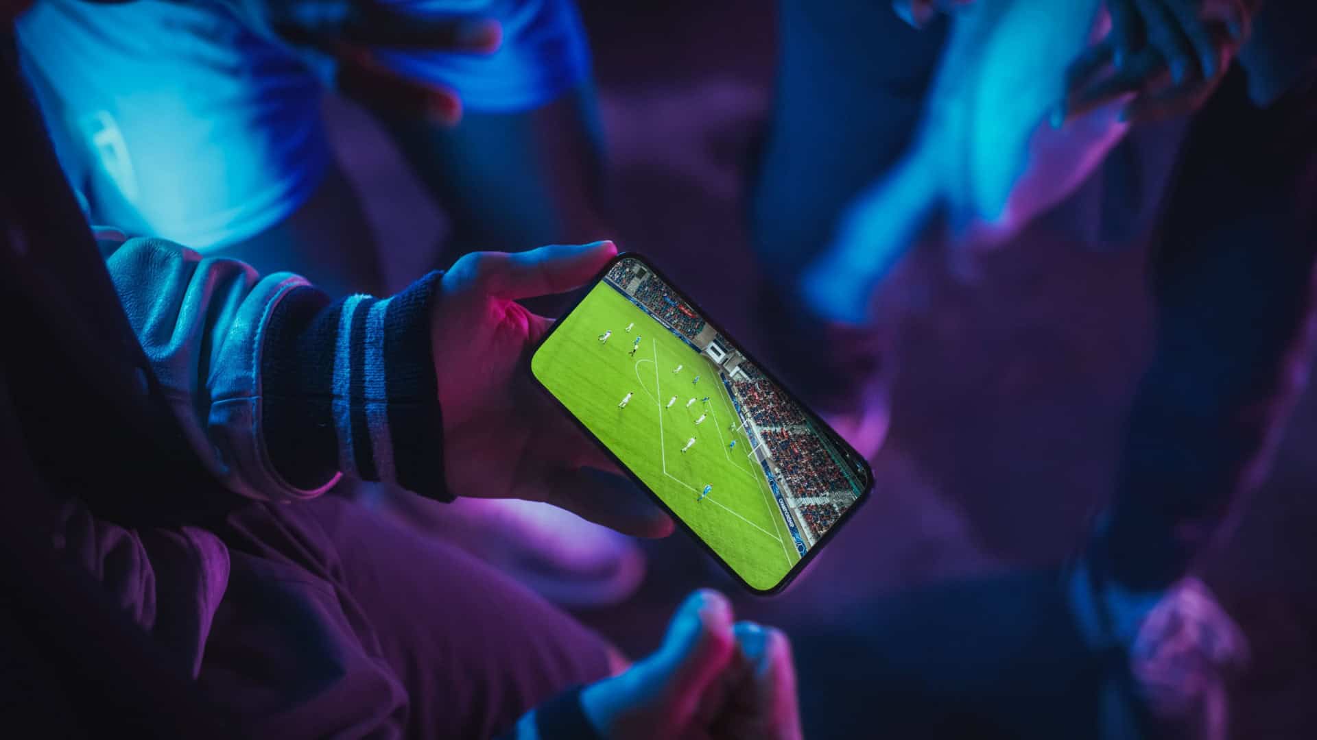 Pessoa assistindo jogo de futebol no celular