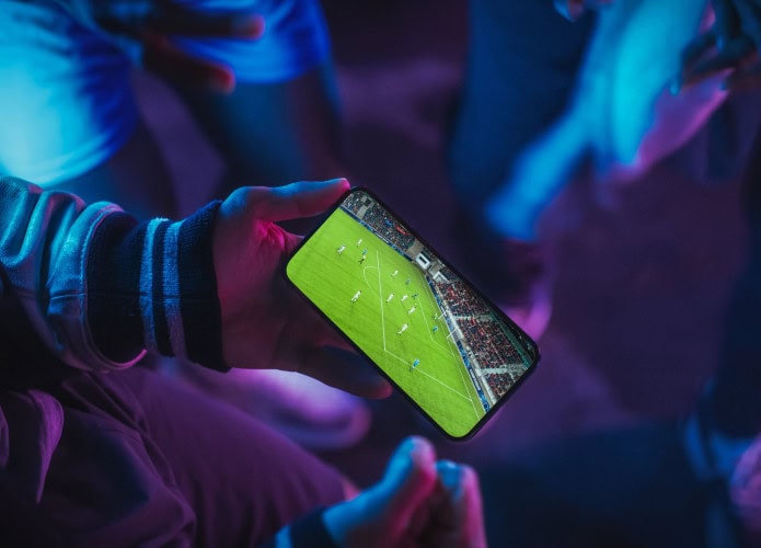Pessoa assistindo jogo de futebol no celular