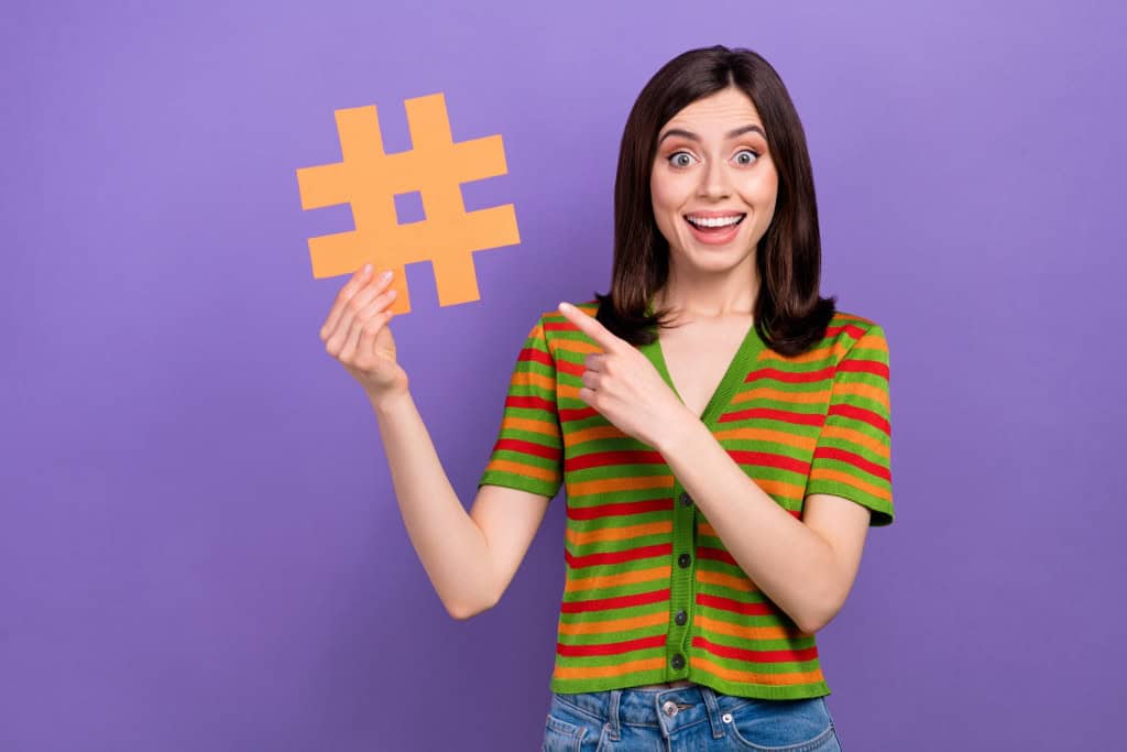 Mulher segurando um símbolo de hashtag